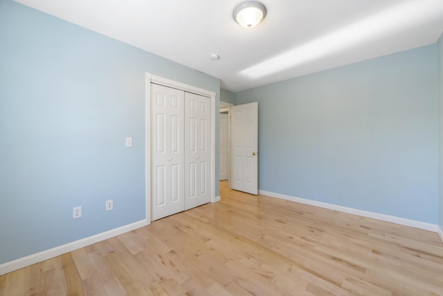 unfurnished bedroom featuring a closet and light hardwood / wood-style flooring