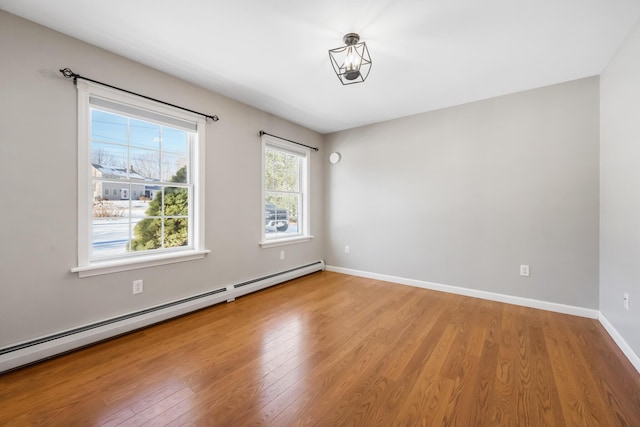 empty room with a baseboard radiator and light hardwood / wood-style floors