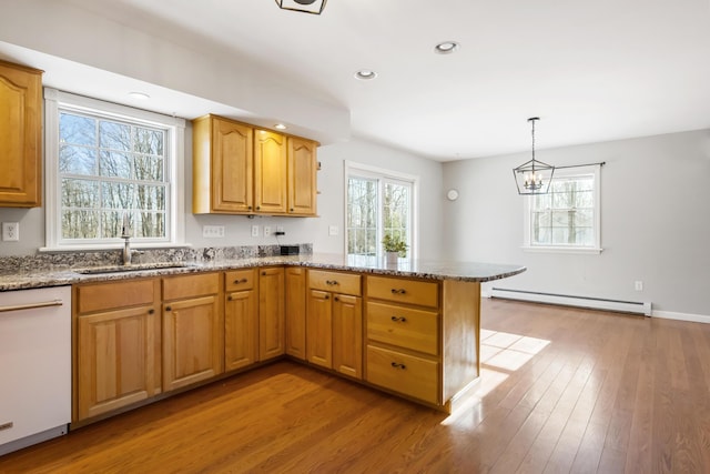 kitchen featuring hanging light fixtures, light hardwood / wood-style flooring, a baseboard radiator, dishwasher, and kitchen peninsula