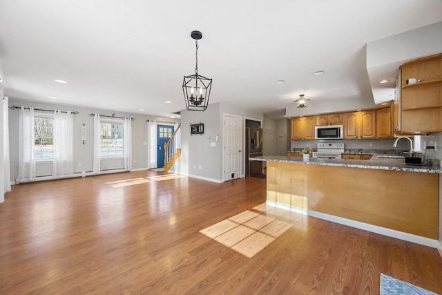 kitchen featuring pendant lighting, stone countertops, white electric range oven, and light hardwood / wood-style flooring