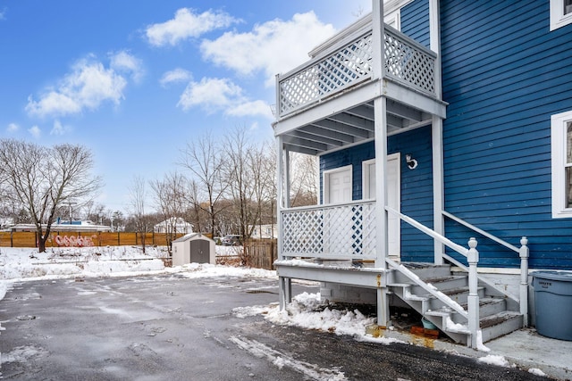 snow covered deck featuring a storage unit