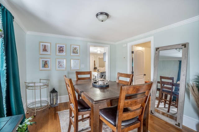 dining space featuring hardwood / wood-style flooring and ornamental molding