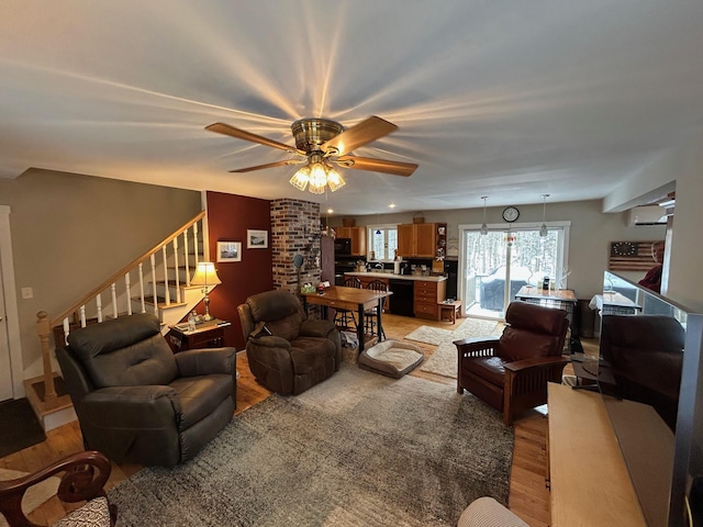 living room featuring ceiling fan and light wood-type flooring