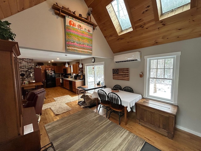 dining area with a skylight, a wall mounted AC, high vaulted ceiling, wooden ceiling, and light wood-type flooring