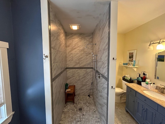 bathroom featuring vanity, tiled shower, and toilet