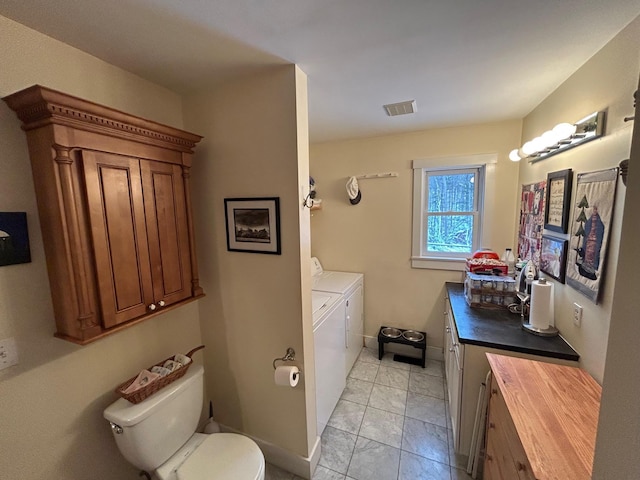 bathroom featuring vanity, independent washer and dryer, and toilet