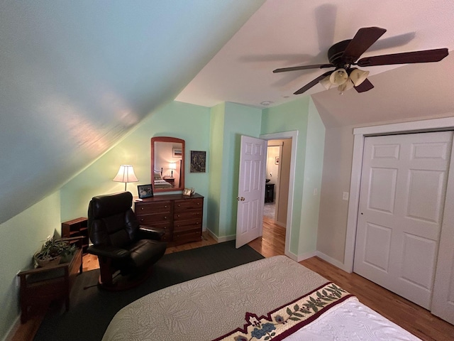 bedroom with lofted ceiling, dark wood-type flooring, ceiling fan, and a closet