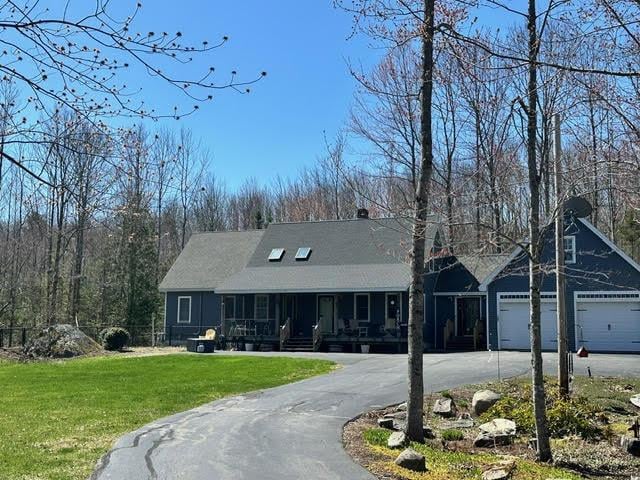 21 Dream Ln, Belfast, ME 04915 - view of front of property featuring driveway, covered porch, a front lawn, and a garage