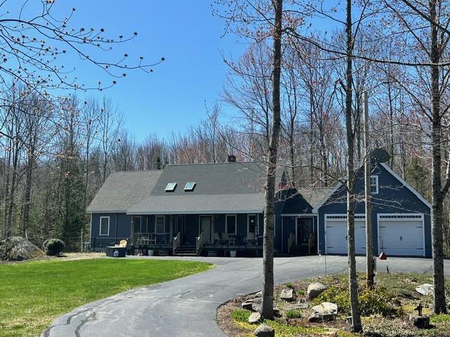 21 Dream Ln, Belfast, ME 04915 - view of front facade with asphalt driveway, a front yard, a garage, and a porch