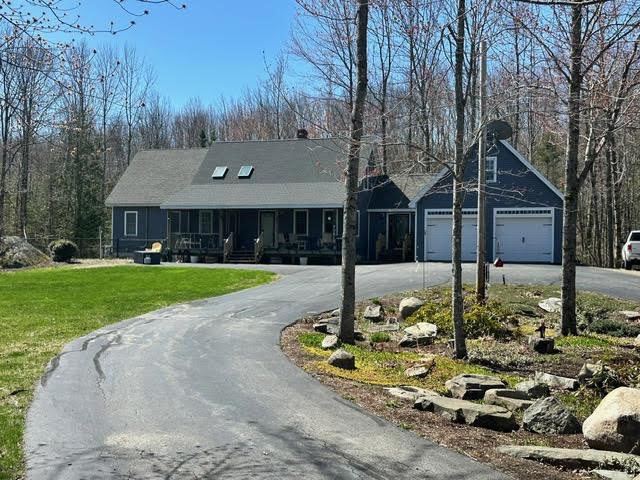 21 Dream Ln, Belfast, ME 04915 - view of front of home with asphalt driveway, a porch, a garage, and a front yard