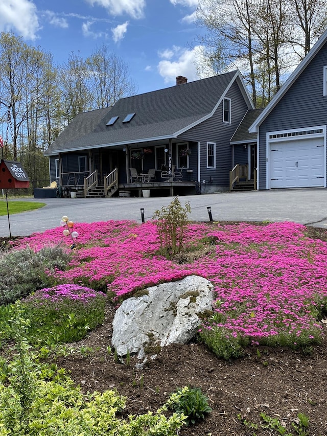 21 Dream Ln, Belfast, ME 04915 - back of property with a chimney, covered porch, a shingled roof, driveway, and a garage