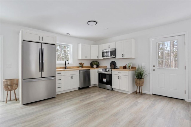 kitchen with white cabinetry, stainless steel appliances, and sink