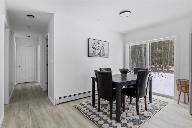 dining space featuring a baseboard radiator and light hardwood / wood-style flooring