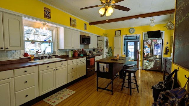 kitchen with sink, stainless steel refrigerator, backsplash, beam ceiling, and range with electric stovetop