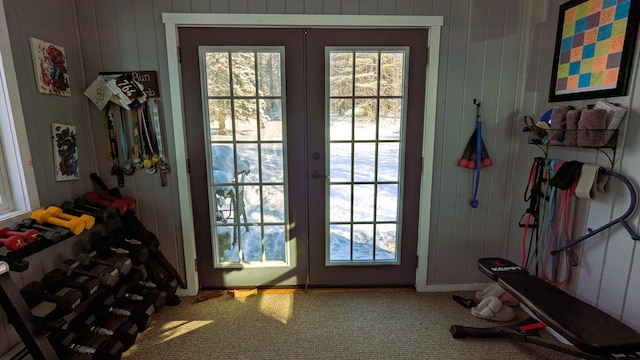 entryway featuring french doors, a healthy amount of sunlight, and carpet floors