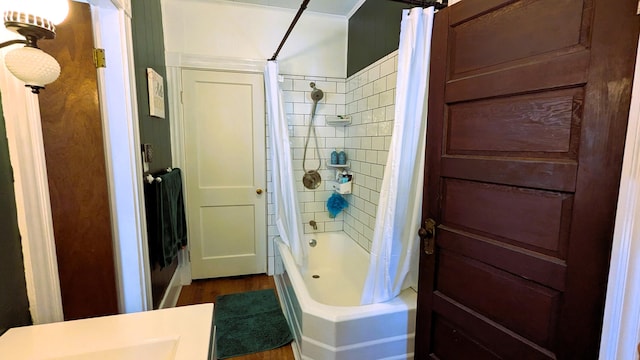 bathroom with hardwood / wood-style flooring and shower / bath combo with shower curtain