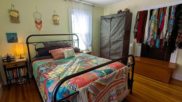 bedroom with wood-type flooring and ornamental molding