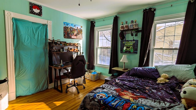 bedroom with wood-type flooring and ornamental molding