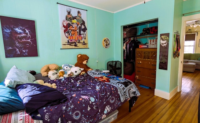 bedroom with crown molding, hardwood / wood-style flooring, and a closet