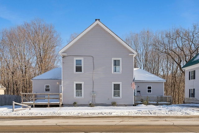 snow covered house featuring a deck