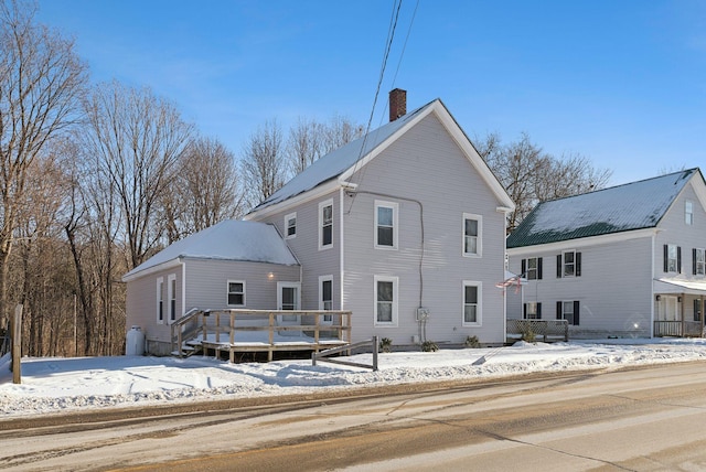 snow covered house with a wooden deck