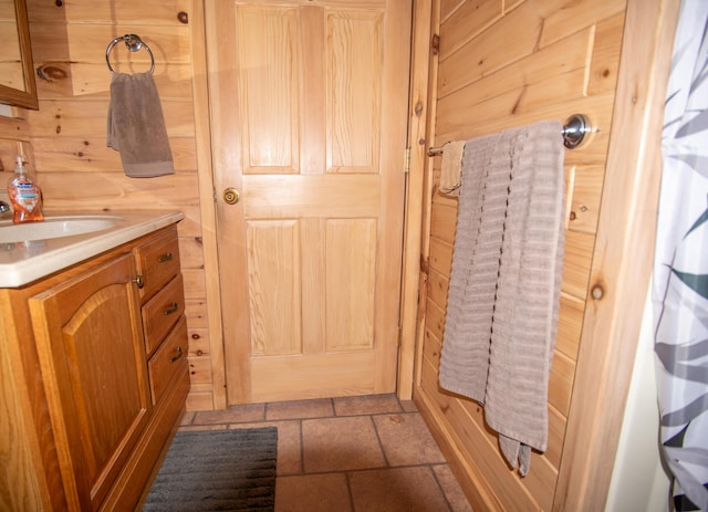 bathroom featuring vanity and wooden walls