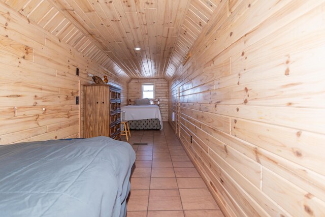 tiled bedroom featuring vaulted ceiling, wooden ceiling, and wood walls