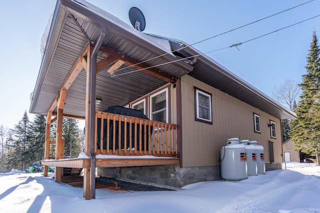 snow covered property with a porch