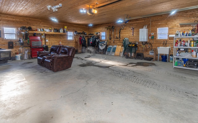 garage with a garage door opener, water heater, wooden ceiling, and a workshop area