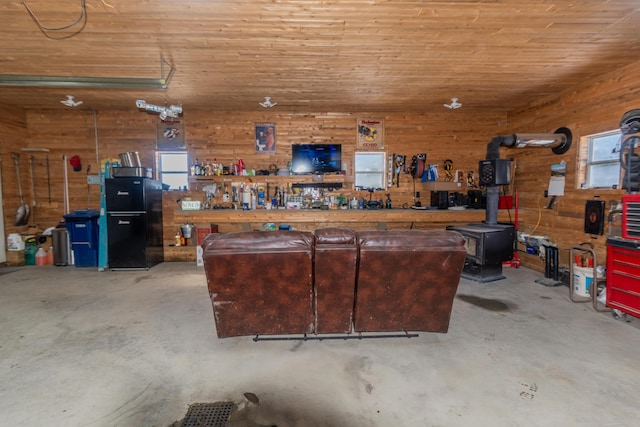 garage with wood ceiling, a workshop area, and a wood stove