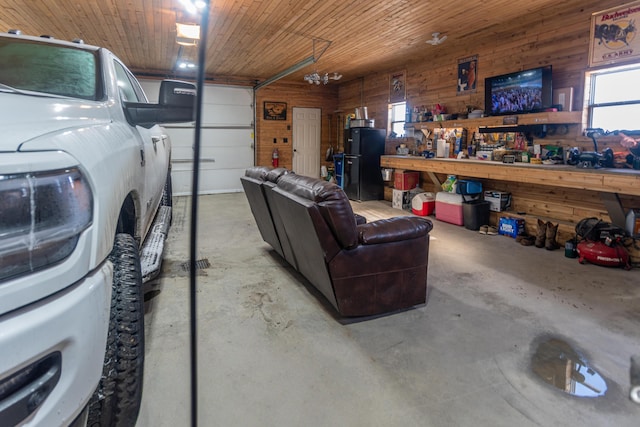 garage with wooden ceiling, wooden walls, and a workshop area