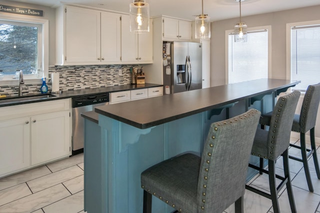 kitchen with appliances with stainless steel finishes, a breakfast bar area, and white cabinets