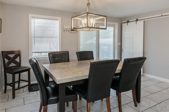 dining space with a barn door and a chandelier