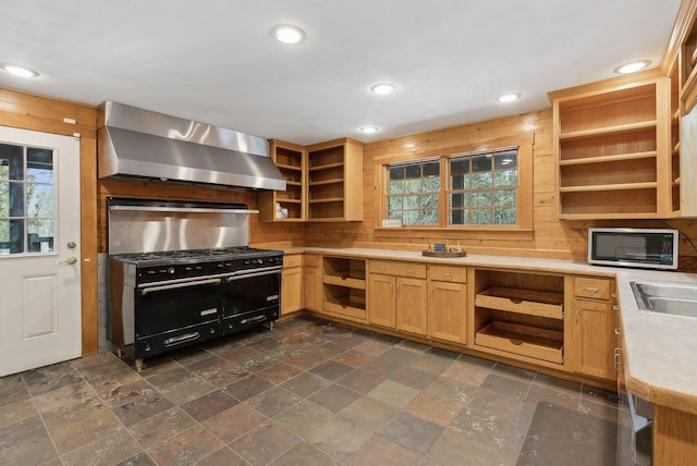 kitchen featuring range with two ovens and wall chimney range hood