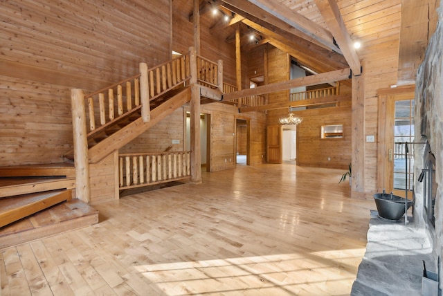 interior space with high vaulted ceiling, wood walls, wooden ceiling, a chandelier, and light wood-type flooring