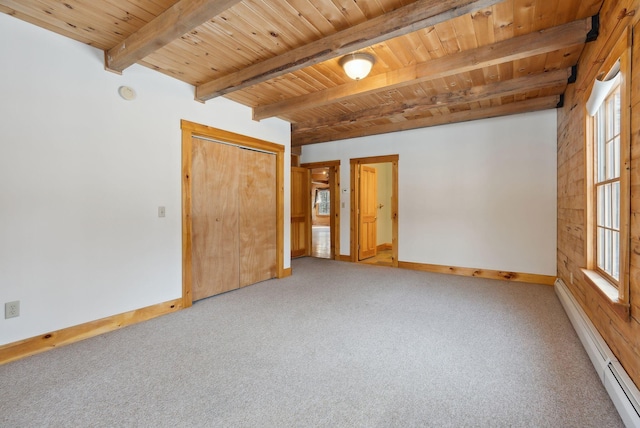 carpeted spare room with beam ceiling, a baseboard radiator, a healthy amount of sunlight, and wood ceiling