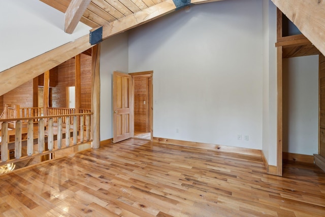 unfurnished living room with hardwood / wood-style floors, wood ceiling, and vaulted ceiling with beams