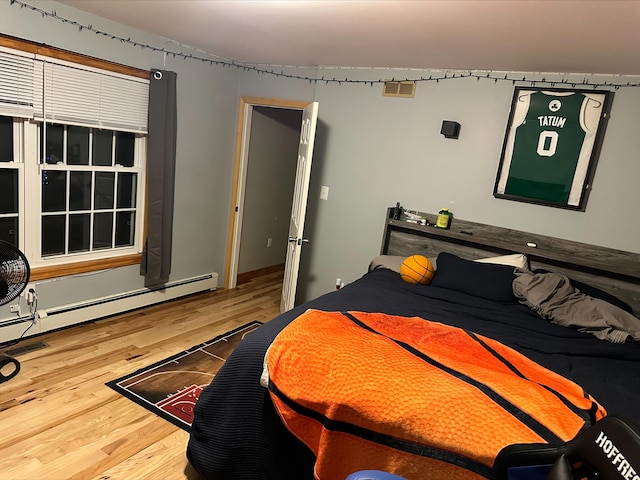 bedroom with hardwood / wood-style flooring and a baseboard radiator