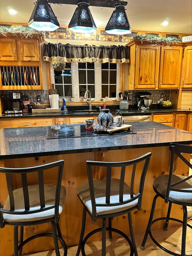 kitchen with tasteful backsplash, sink, and a breakfast bar