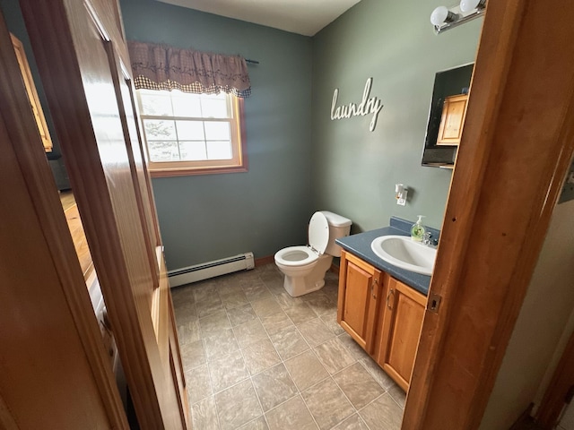 bathroom featuring vanity, baseboard heating, and toilet