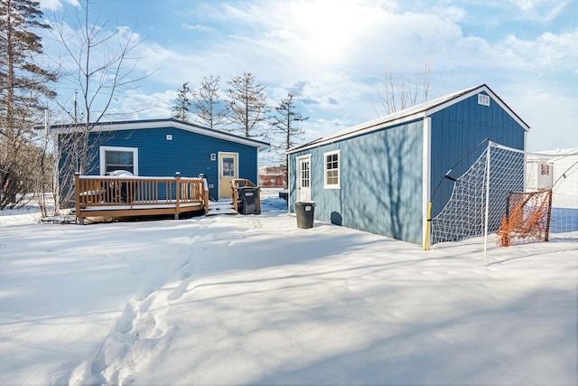 snow covered rear of property featuring a deck