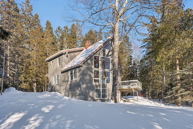 snow covered property with a deck