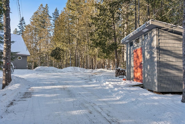 yard layered in snow with a storage shed