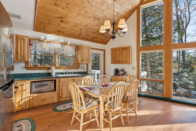 dining room featuring a notable chandelier, light hardwood / wood-style floors, sink, and wooden ceiling