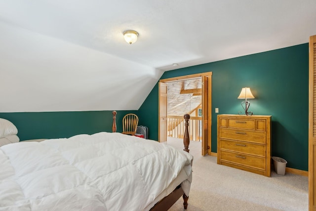 bedroom featuring light colored carpet and vaulted ceiling