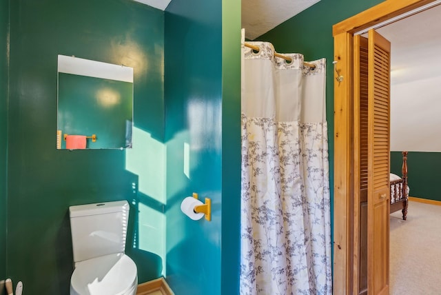 bathroom featuring a shower with curtain and toilet