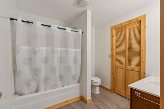 full bathroom featuring vanity, hardwood / wood-style floors, shower / bath combination with curtain, and toilet