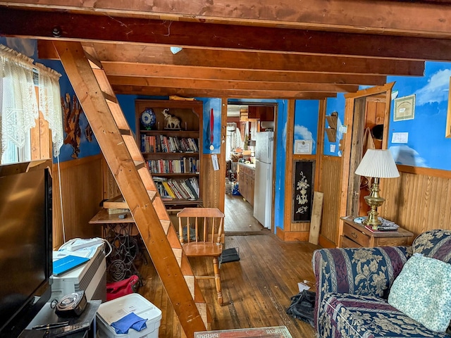 living room with beam ceiling, wood-type flooring, and wooden walls