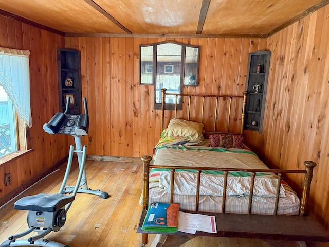 bedroom with wood-type flooring and wood walls