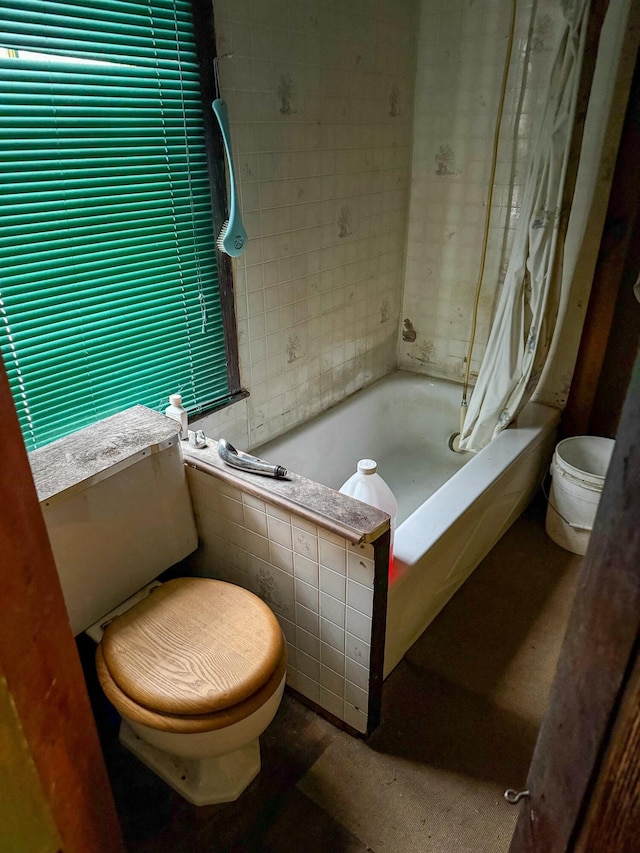 bathroom featuring toilet and tiled tub